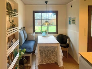 Ein Zimmer mit Tisch, Bank und Fenster.