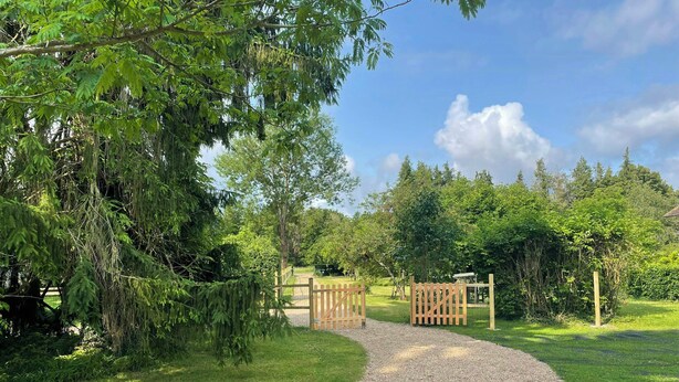 A gravel path leading to a wooden gate in a lush green garden. - Charming house by the Seine in Normandy (Poses)