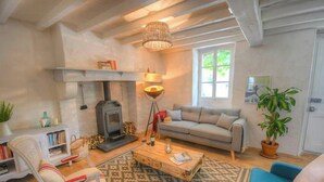A cozy living room with a fireplace, sofa, coffee table, and a bookshelf. - Riverside house with farm animals in Béarn (Autevielle-Saint-Martin-Bideren)