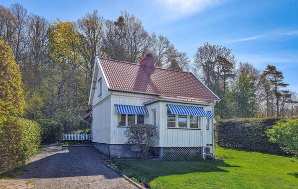 A two-story house with a red-tiled roof, a gravel driveway, and a well-maintained lawn. - Stunning home in Billdal with WiFi (Billdal)