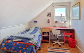 A dormitory room with a bunk bed, a desk with a chair, a window with a view, and a red basket. - Stunning home in Billdal with WiFi (Billdal)