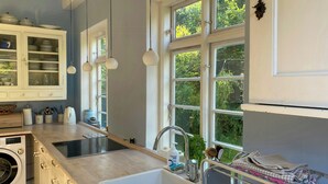 A modern kitchen with a built-in washing machine, a sink, and a drying rack. - Villa from 1917 high above Tisvildeleje (Tisvilde)