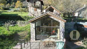 A stone cabin with a balcony, large windows, and a wooden deck. - 17th century renovated barn in Valdeblore (Valdeblore)