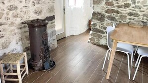 A rustic room with stone walls, a wooden table, and a chair. - 17th century renovated barn in Valdeblore (Valdeblore)