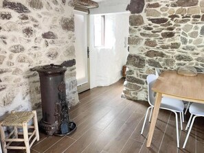 Una habitación rústica con paredes de piedra, una mesa de madera y una silla.