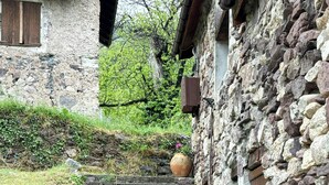 A stone staircase leading to a rustic building with a wooden door and a large pot on the wall. - 17th century renovated barn in Valdeblore (Valdeblore)