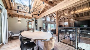 Ein geräumiges Zimmer mit einem großen runden Tisch, modernen Stühlen und einer Glastrennwand.