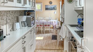 A compact kitchen with a coffee maker, microwave, and sink. There is a dining area with a table and chairs. - Beautiful home in Nynäshamn with WiFi (Nynäshamn)