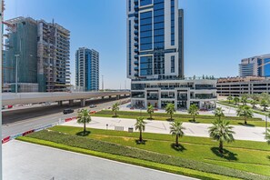 A modern building with a central atrium, surrounded by landscaped areas with palm trees. - Chic Studio with Private Terrace in Business Bay Near Burj Khalifa (Dubai)