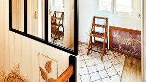 Een kamer met een grote spiegel, houten meubels, een kamerbreed tapijt en uitzicht door een raam.