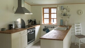 Una cocina con estufa, horno, pileta y encimera de madera.