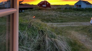 Ländliche Landschaft mit Häusern und Sonnenuntergang.