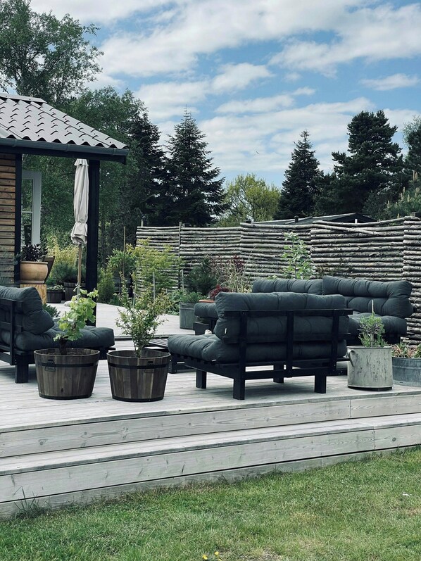 Un espace extérieur aménagé avec une terrasse en bois, un patio couvert et une clôture en bois.