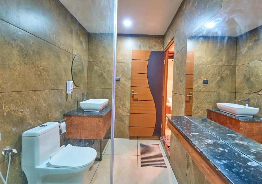 Un bagno con servizi igienici, lavandino e specchio.