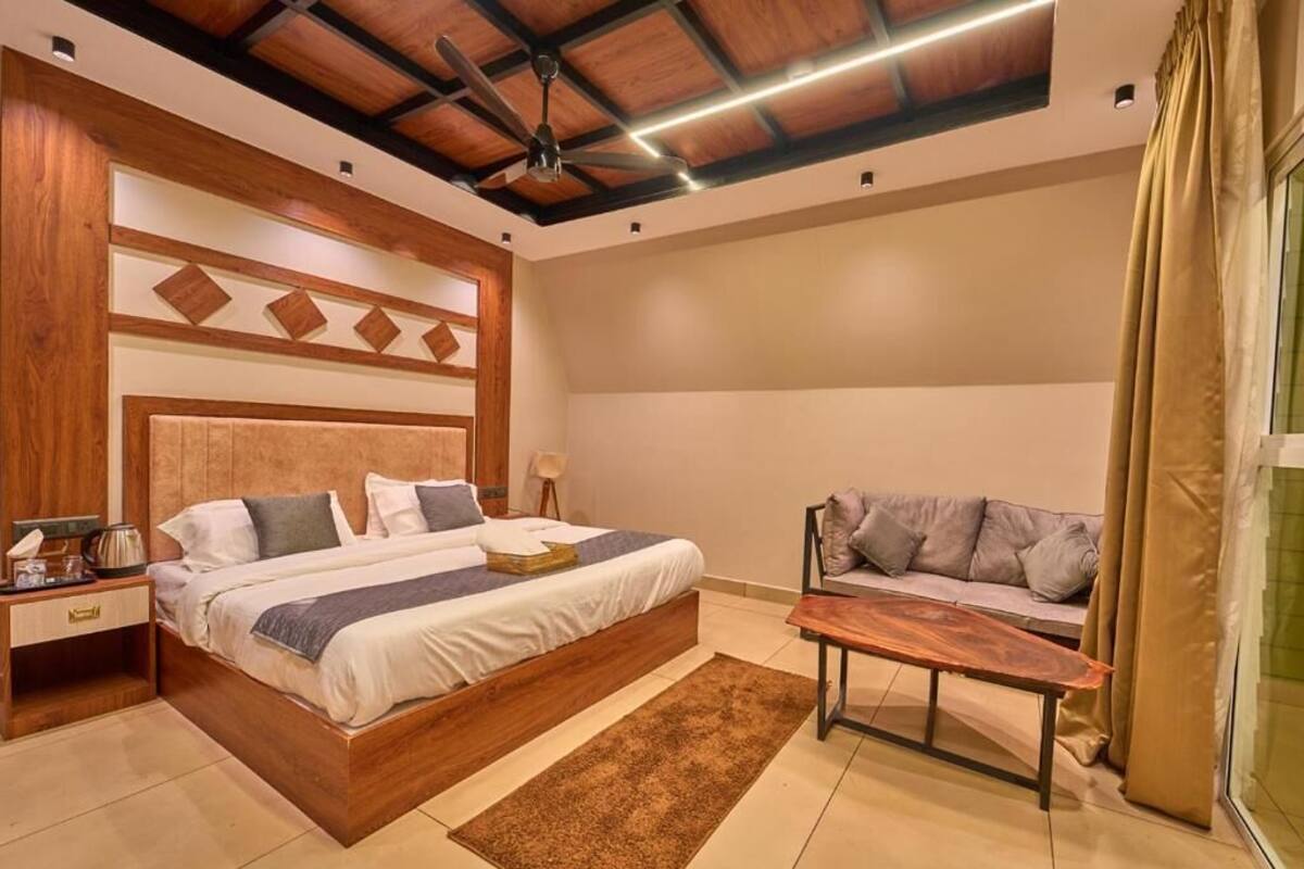 Un dormitorio con cama, mesita de noche y un banco de madera.