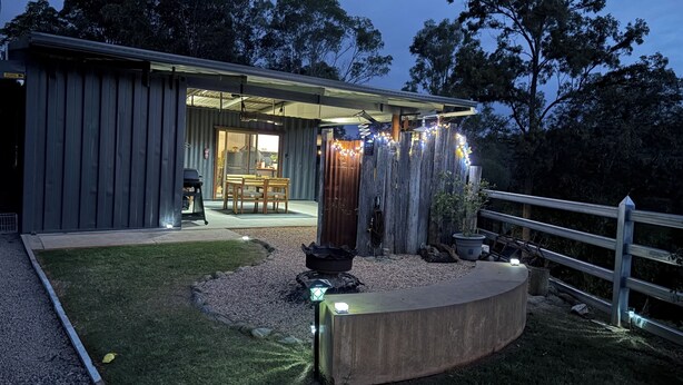 A modern building with a covered patio, outdoor seating, and string lights.
