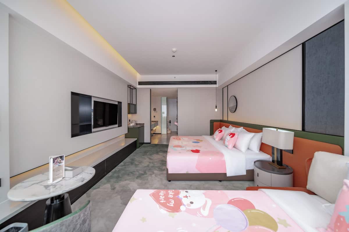 A hotel room with a bed, bedside table, lamp, TV, and a small round table with a chair.