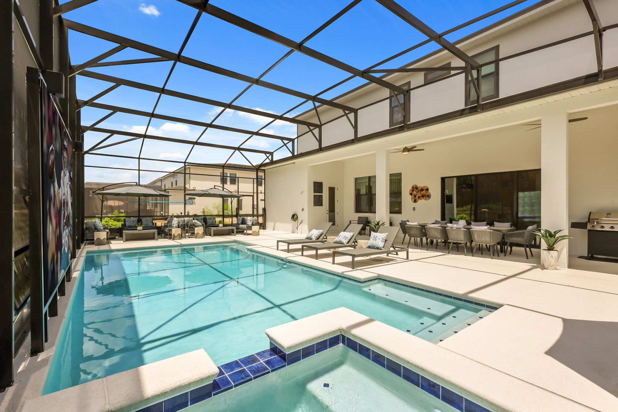 A swimming pool with sun loungers and a covered patio area.