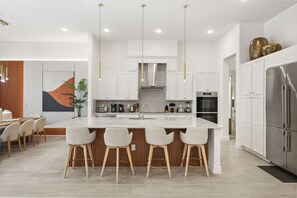 A modern kitchen with a large island, bar stools, and stainless steel appliances. - 15 BD/ 16.5 BA/ Sonoma Resort (4141 SB) (Kissimmee)