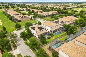 A residential area with houses, green lawns, and a swimming pool. - 6 BD/ 6 BA/ Champions Gate (1510 RF) (Davenport)