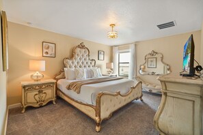 A classic bedroom with a large bed, ornate headboard, and a chandelier. - 6 BD/ 6 BA/ Champions Gate (1510 RF) (Davenport)