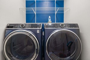 Two front-loading washing machines with control panels, a blue shelf above them, and a white wall. - 6 BD/ 6 BA/ Champions Gate (1510 RF) (Davenport)