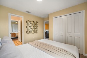 Une chambre à coucher comprenant un lit, une armoire et un élément décoratif mural.