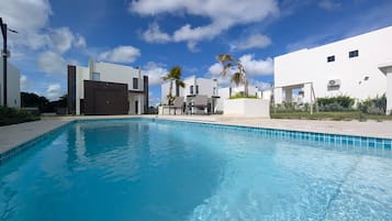 A swimming pool with modern buildings in the background.