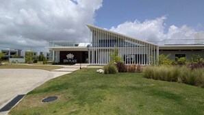 Un bâtiment moderne, avec une enseigne indiquant « ZEN PLACE », et une pelouse bien entretenue devant.