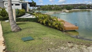 Un bâtiment moderne doté d’une piscine, de palmiers et offrant une vue sur un lac.