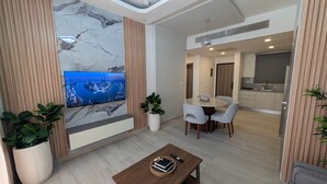 Un soggiorno moderno con TV, zona pranzo e cucina.