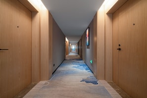A hotel hallway with wooden doors, a carpeted floor, and a long corridor. - Huapeng International Guangzhou (Guangzhou)