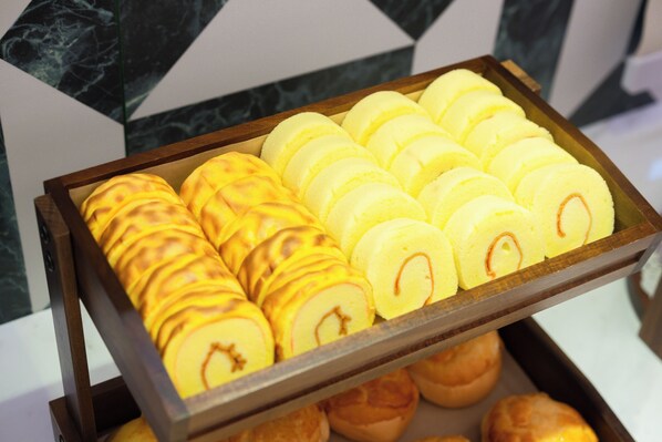 A tray of pastries with a variety of shapes and designs, including swirls and dots.