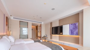 A hotel room with two beds, a TV mounted on the wall, a small table, and a mirror. - Lavande International Huawei Guangzhou  (Guangzhou)