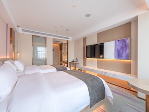 A hotel room with two beds, a TV mounted on the wall, a small table, and a mirror. - Lavande International Huawei Guangzhou  (Guangzhou)