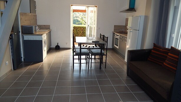 Una cocina amplia con comedor, sofá y vistas al exterior.