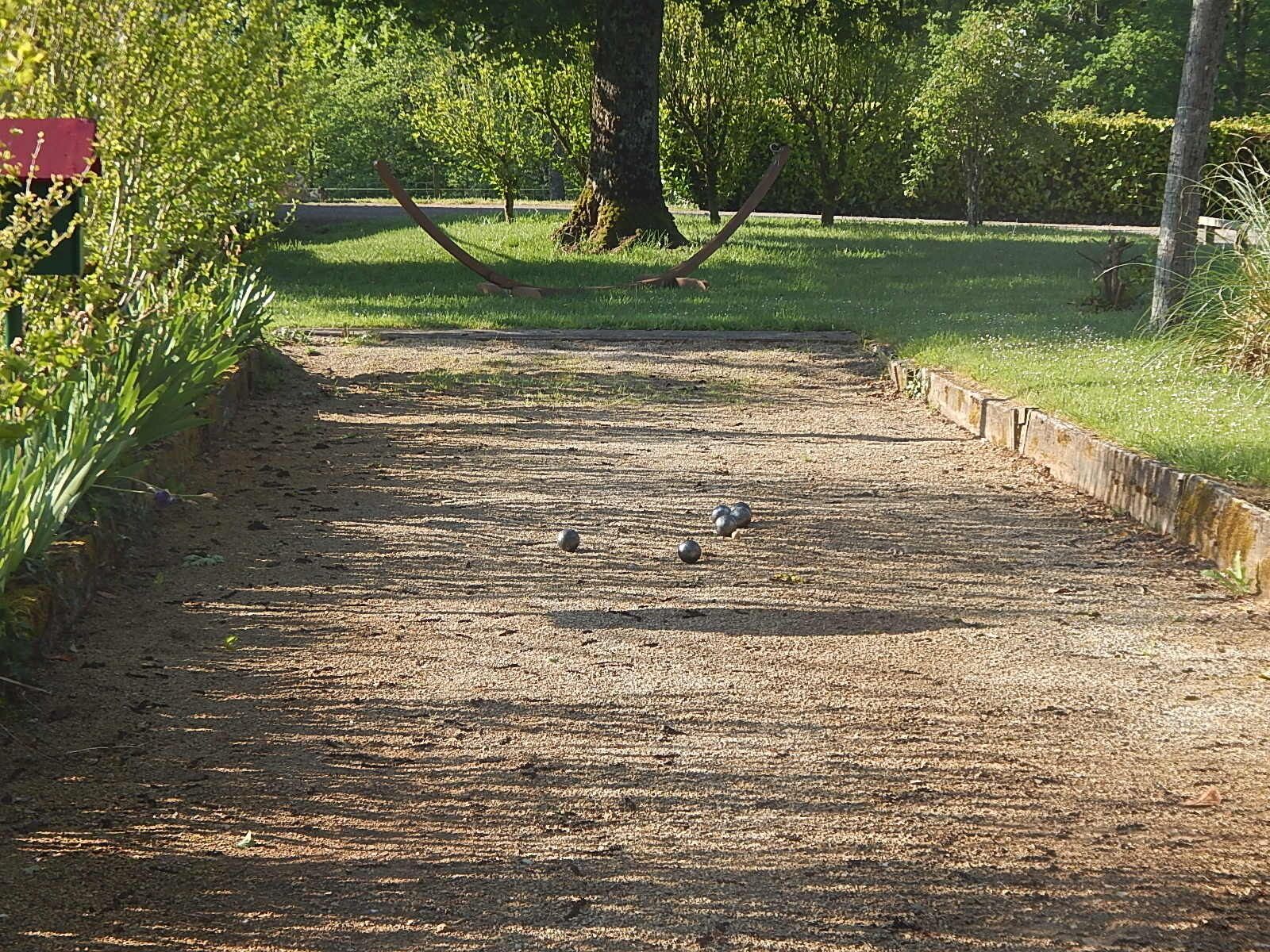 A gravel path in a park with trees and grass on either side.