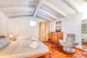 Een slaapkamer met een bed, een stoel, een dressoir en een kledingkast.