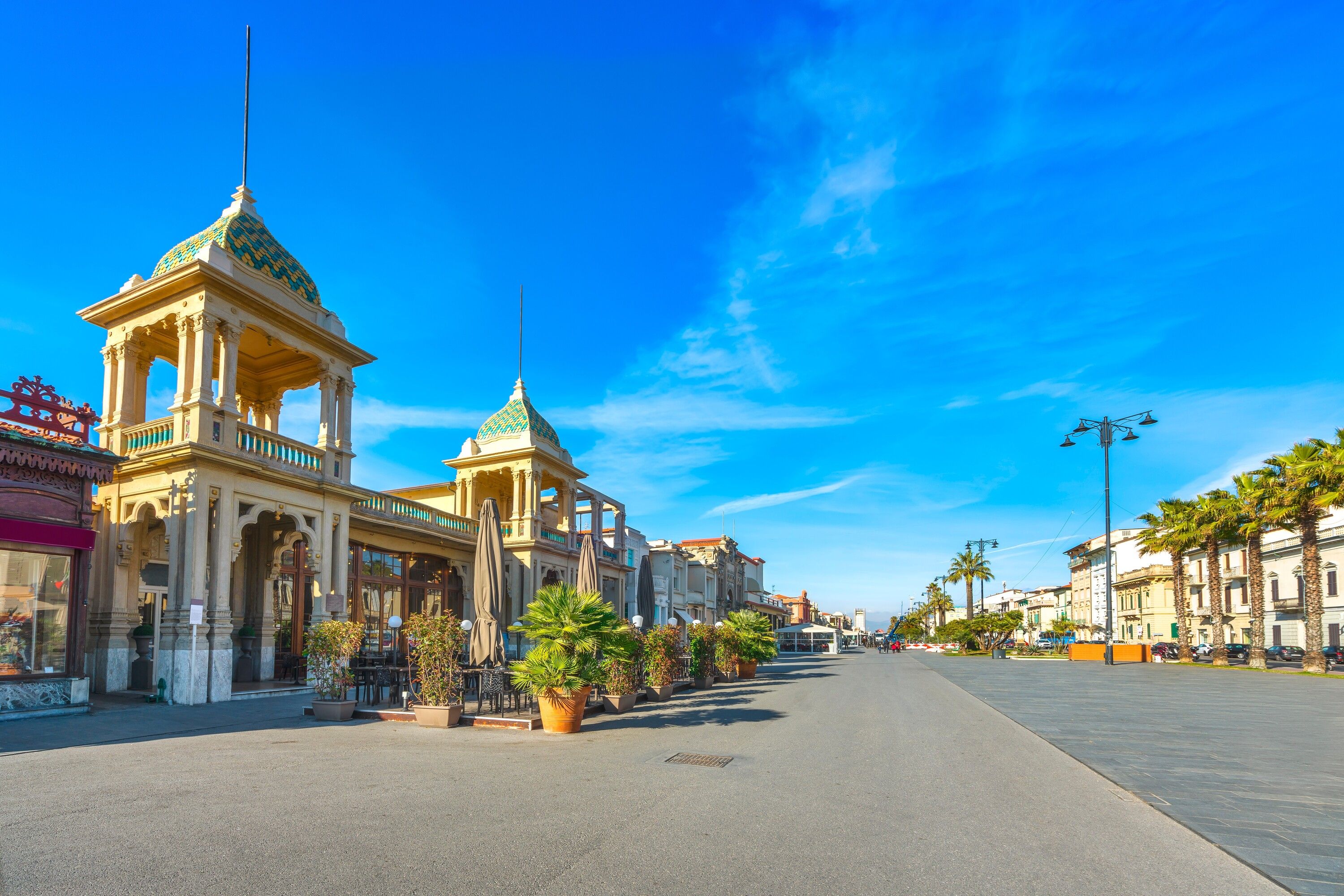 A wide street with a prominent building featuring a green dome and columns.