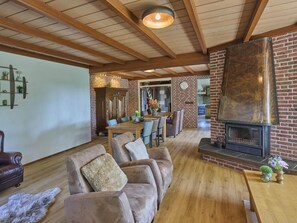 A cozy living room with a fireplace, leather sofas, and a dining area.