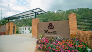 A wellness sanctuary entrance with a brick wall, a covered walkway, and a sign.