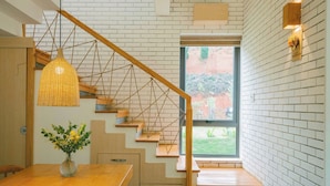 A staircase with wooden steps and a woven light fixture.