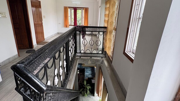 Una escalera con barandilla negra, un letrero que indica habitación privada y vistas al exterior por una ventana.