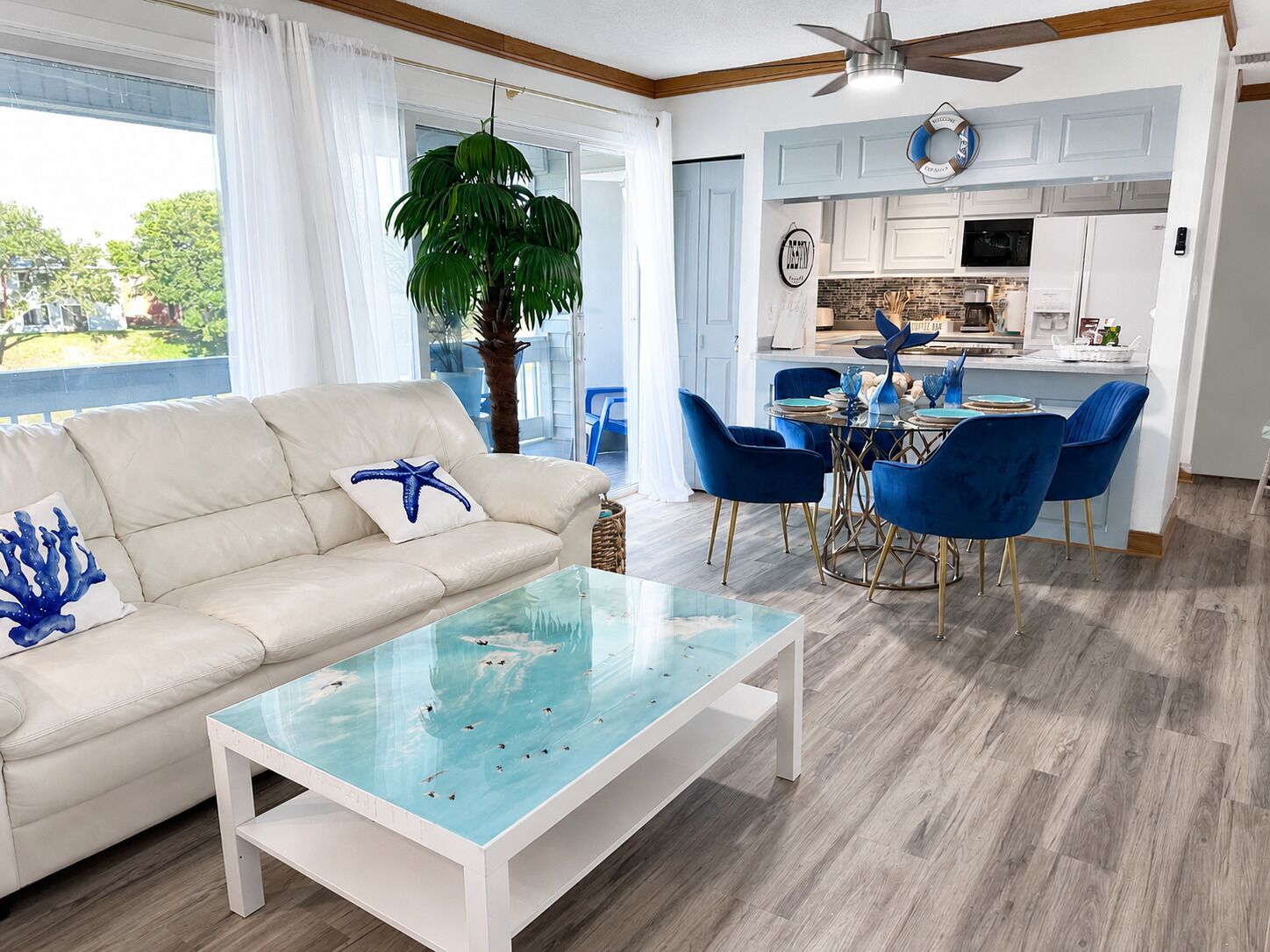 A living room with a sofa, coffee table, and dining area with chairs.