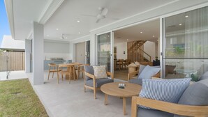 A spacious patio with a dining area, a sofa set, and a ceiling fan. - Offshore Escape - Welcome to your dream North Coast escape (Skennars Head)