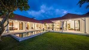 A modern house with a swimming pool, covered patio, and a well-maintained lawn. - Specious 3Bedroom Rakuen Villa Canggu (Canggu)