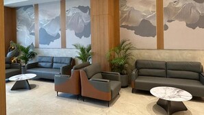 A modern lobby with a sofa, armchairs, and a coffee table.