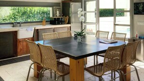 Une cuisine moderne avec un coin repas, de grandes fenêtres et un ventilateur de plafond.