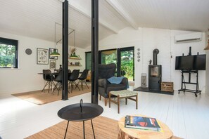 A modern living room with a dining area, a fireplace, and a television. - Summer house in Houstrup with scenic views (Nørre Nebel)