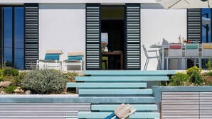 Ett modernt hus med en swimmingpool, utomhusmöbler och en uteplats.